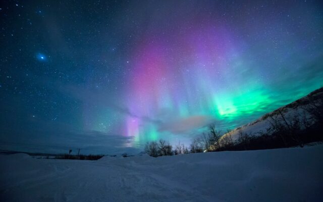 Aurora boreal no céu noturno durante o Natal, um dos destinos mais buscados pela Vita Voyage