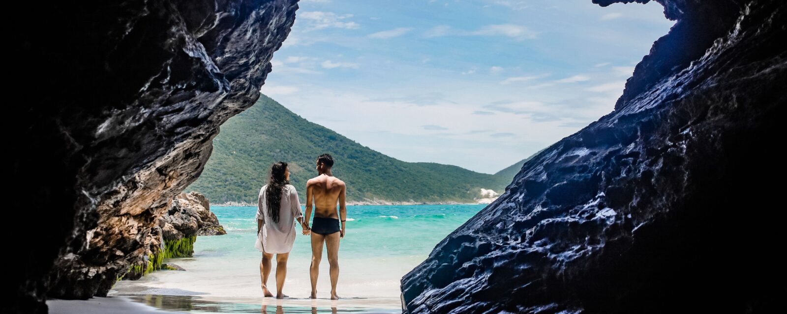 Casal observando uma praia, ilustrando quanto custa uma viagem de bodas