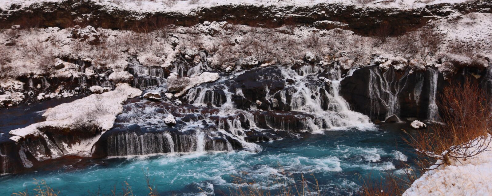 Paisagem congelada da Islândia durante o Ano Novo, com cachoeira e neve