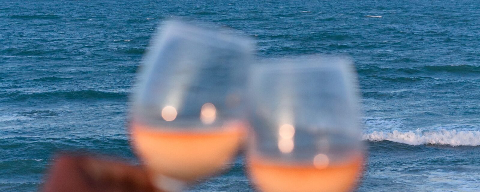 Casal brindando à beira-mar, um dos destinos no Brasil para aniversário de casamento