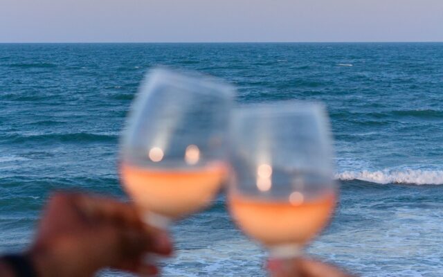 Casal brindando à beira-mar, um dos destinos no Brasil para aniversário de casamento