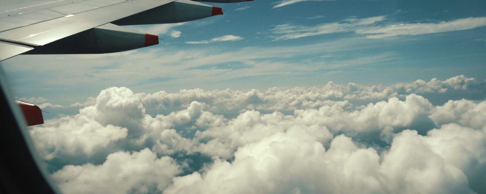 Avião sobre as nuvens ilustrando quando comprar viagem de Ano Novo com a Vita Voyage