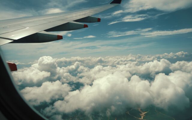 Avião sobre as nuvens ilustrando quando comprar viagem de Ano Novo com a Vita Voyage